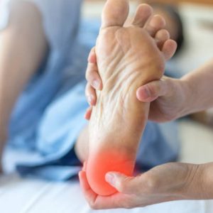Heel Pain or plantar fasciitis concept. Hand on foot as suffer from inflammation feet problem of Sever's Disease or calcaneal apophysitis.
